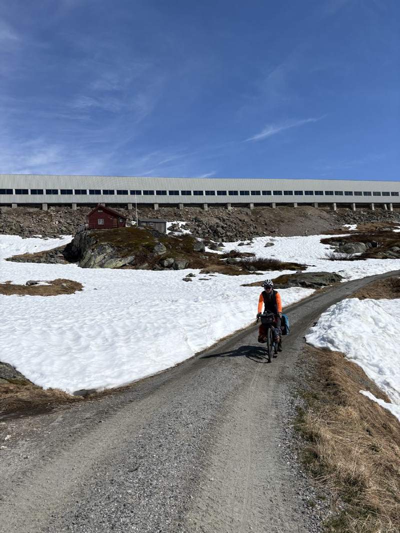 碎石路上騎車的背影,後面是鐵道的防雪棚。