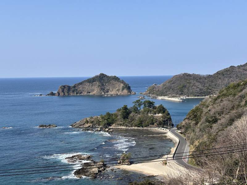 惣津海岸與明島,道路沿著海灣繞過去。
